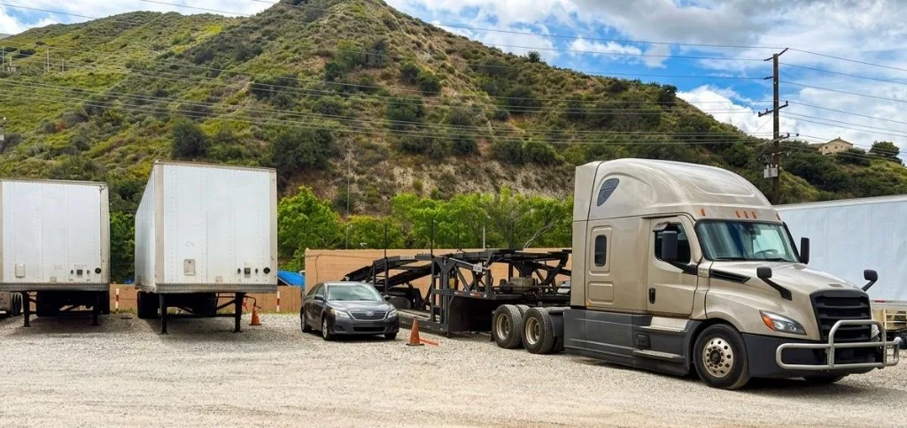 Champagne semi-truck with an empty car-hauler trailer parked at the Santa Clarita commercial storage facility