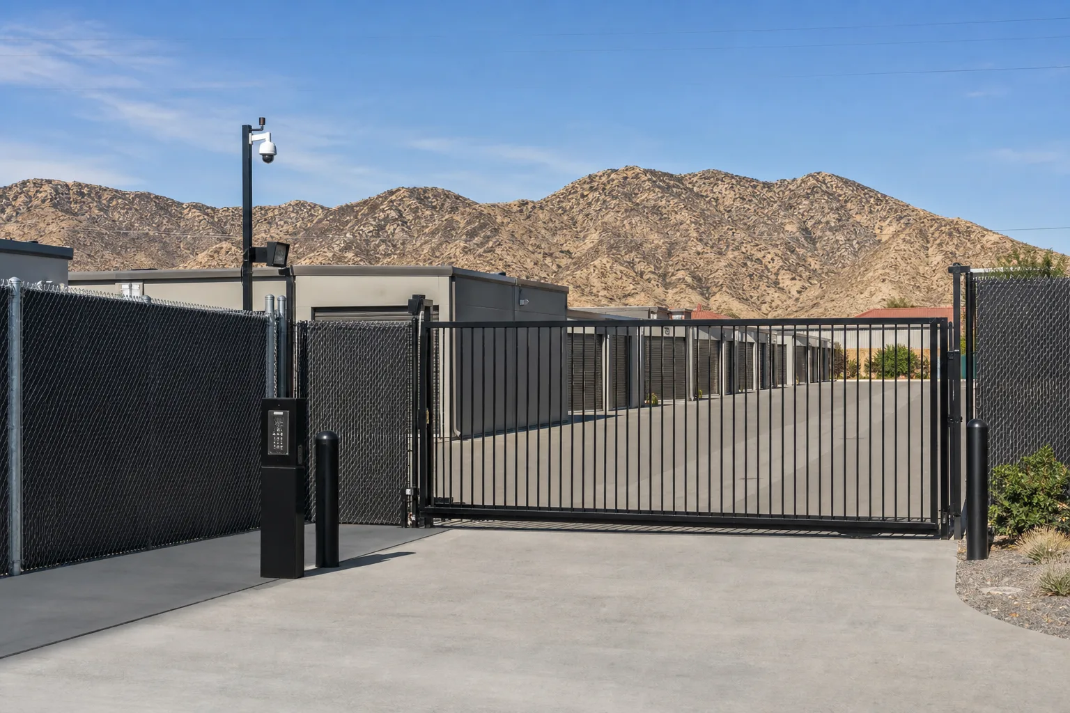 Secure gated entrance of the commercial truck storage facility with keypad access post and perimeter fencing