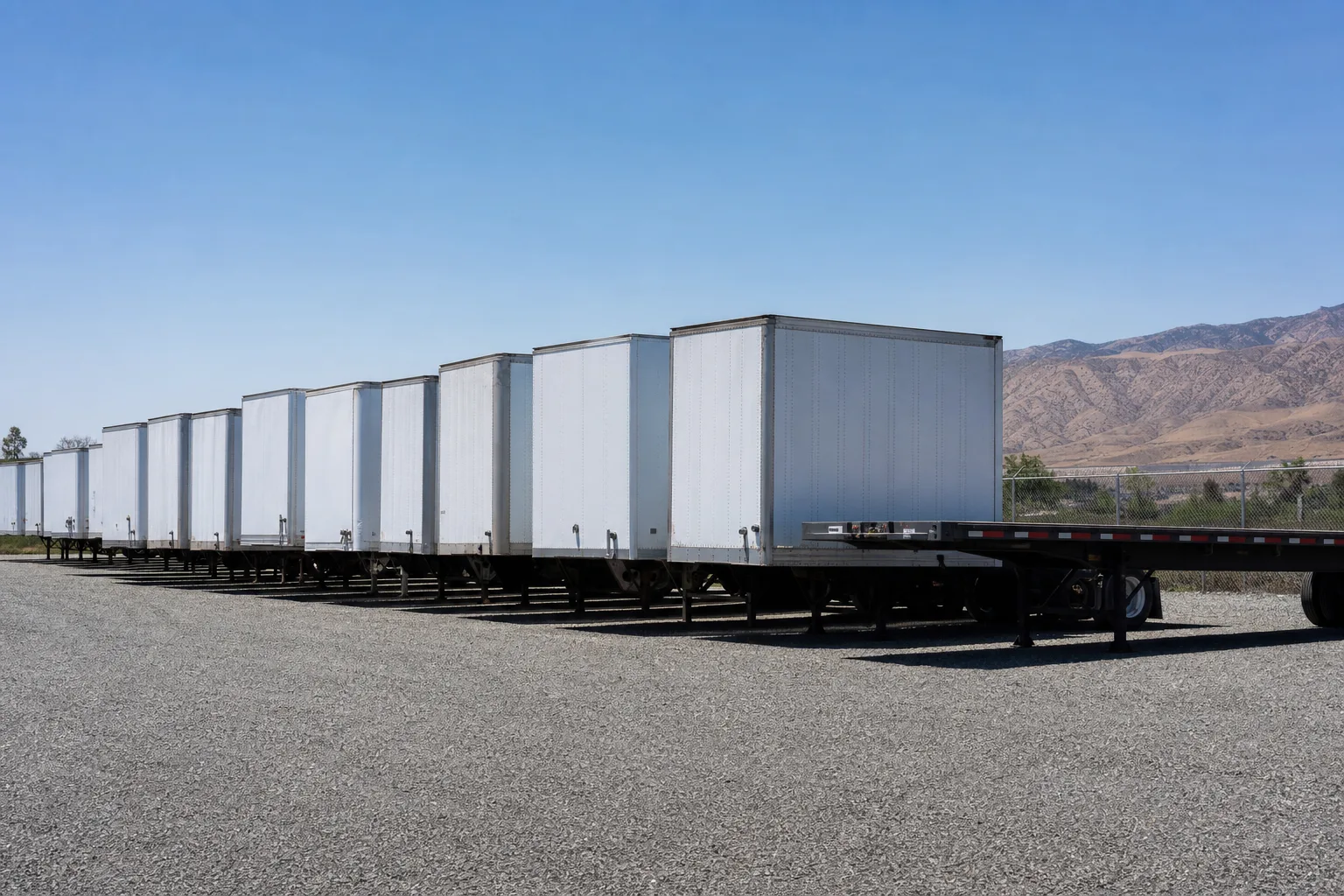 Row of dry van and flatbed semi-trailers stored on the Sierra Highway facility yard